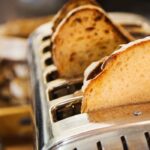 A loaf of bread being wrapped in aluminium foil for freezing