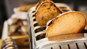 A loaf of bread being wrapped in aluminium foil for freezing