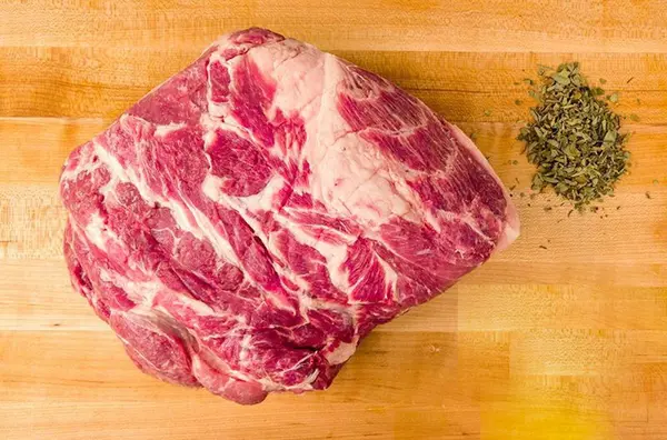 Image of a beautifully cooked bone-in pork butt, showcasing its juicy, tender meat and golden-brown crust, ideal for pulled pork dishes.