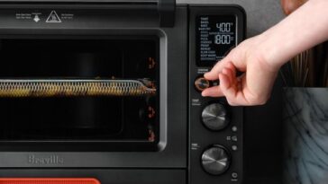 A food dehydrator machine with various fruits and vegetables arranged inside, illustrating the process of drying food while keeping the machine cool for optimal flavor and nutrient retention.