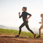 A person jogging on a scenic trail, symbolizing the continuous journey of physical fitness through consistent exercise, progress, and healthy lifestyle choices.