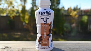 A bottle of Fairlife Protein Shake with a label highlighting its high protein content, low sugar, and essential nutrients like calcium and vitamin D.